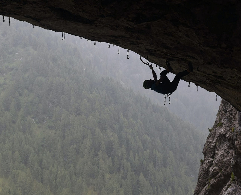 Rock climber climbs a steep overhang.
