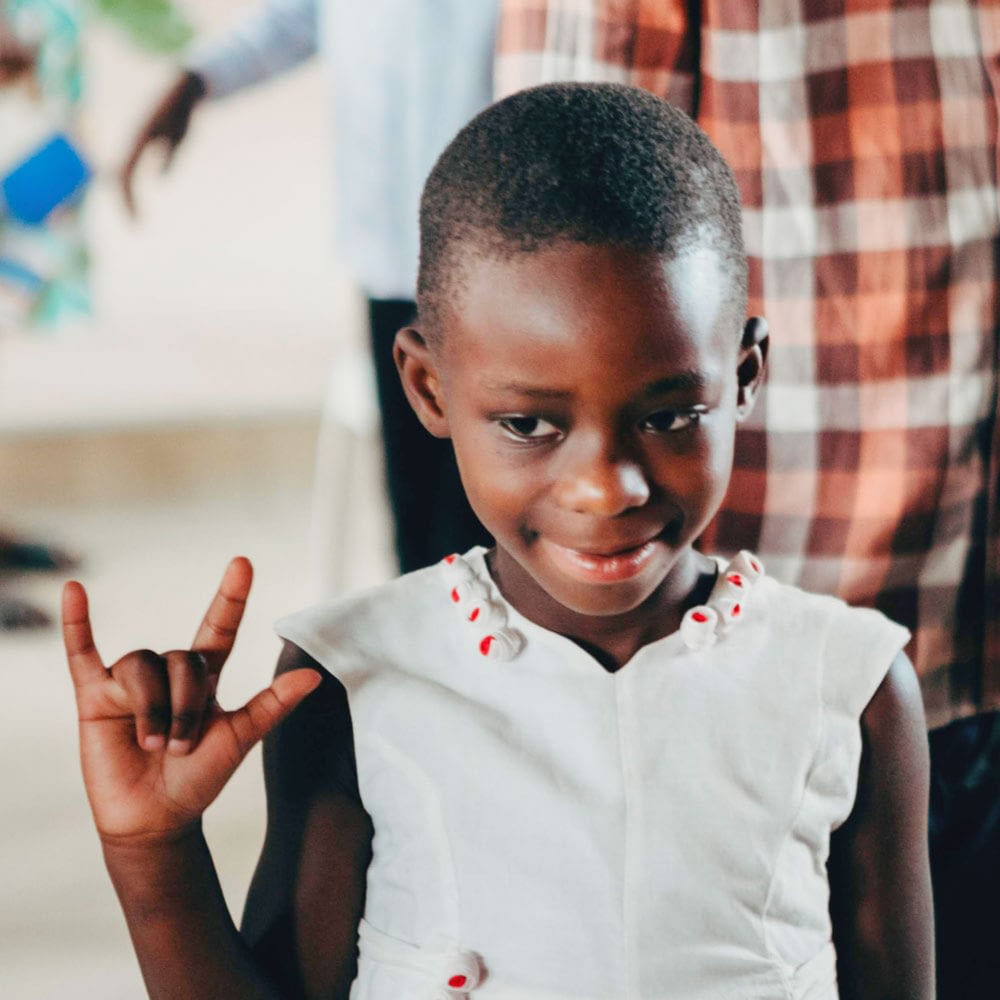 Young child signs "I love you"