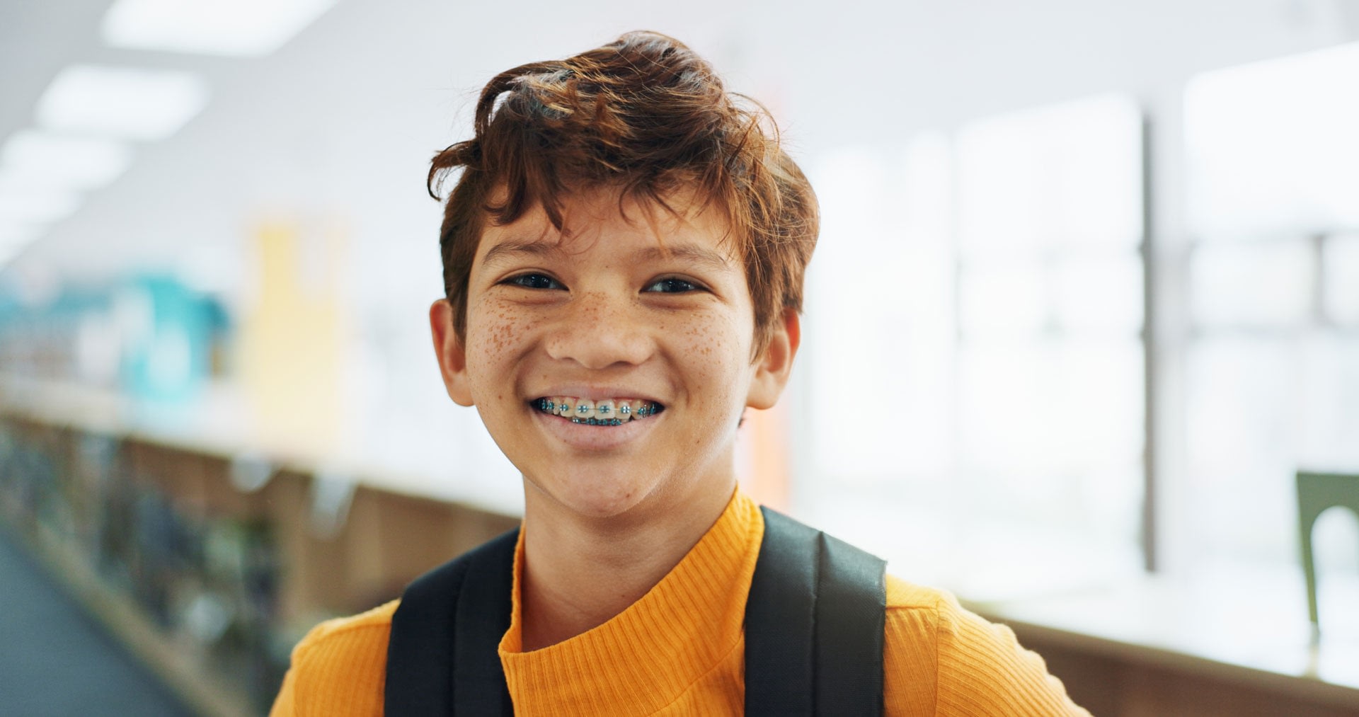 Smiling child with braces in school hallway
