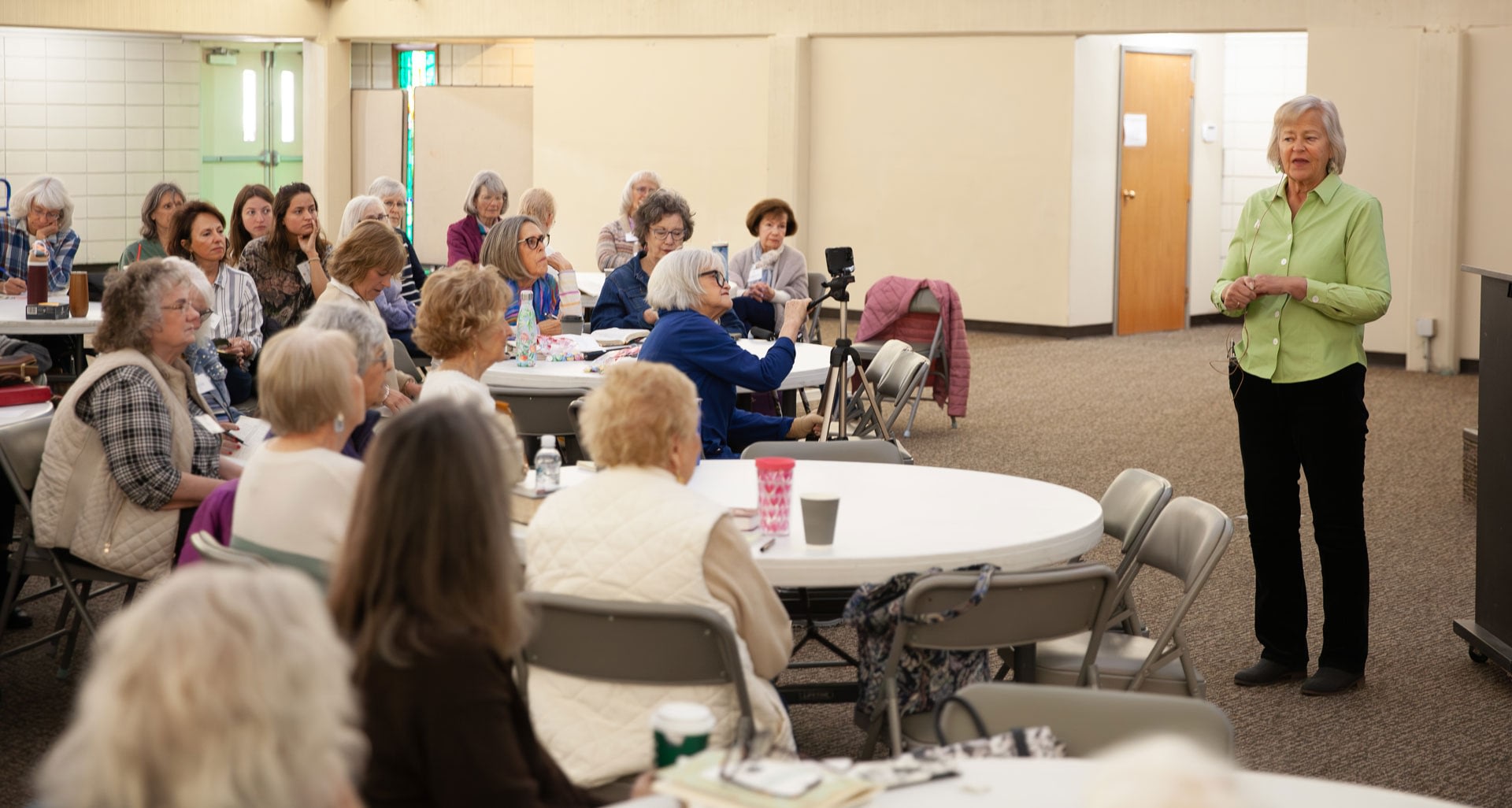 Woman speaking to seated community group indoors
