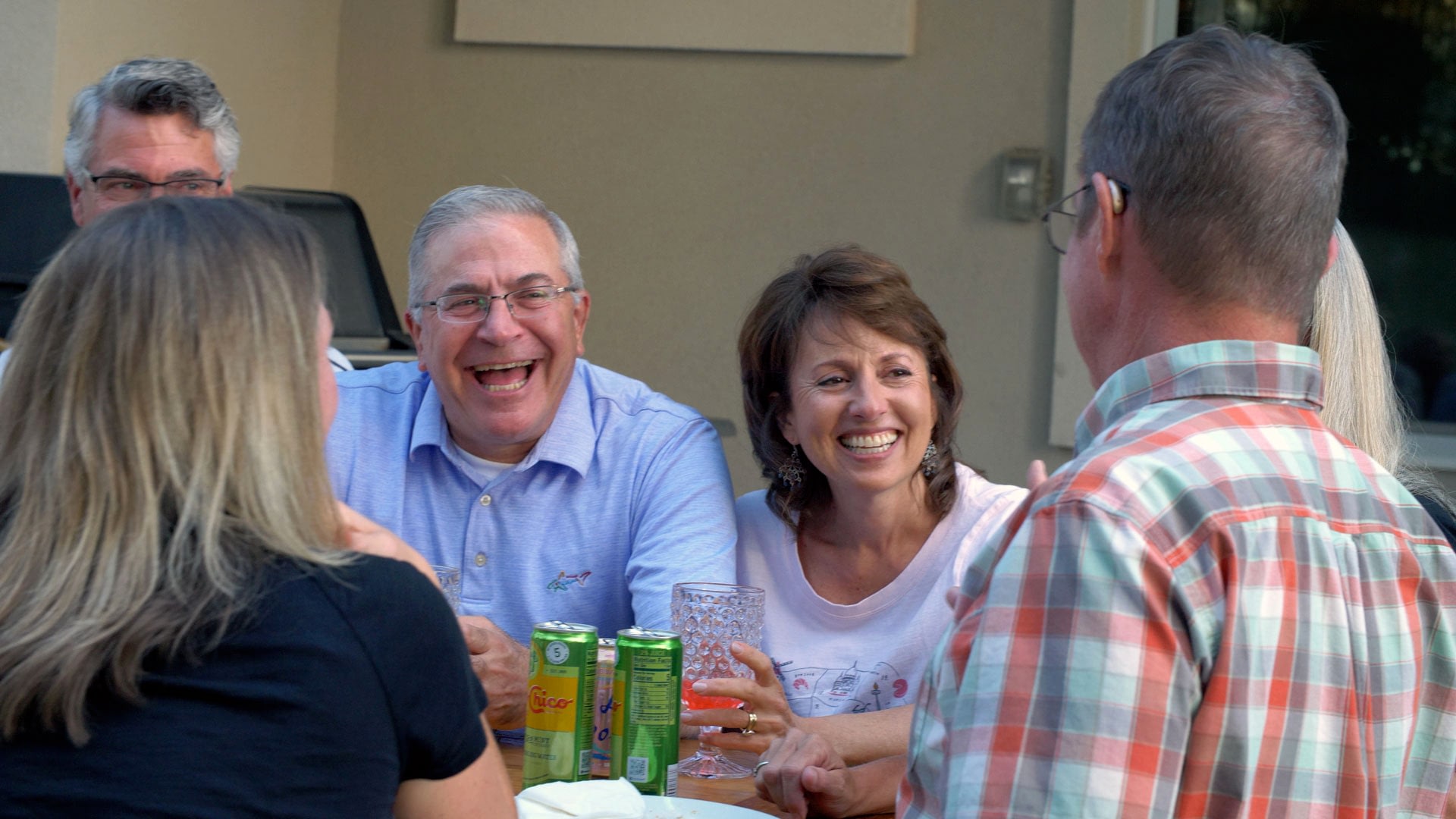 Friends laughing together at outdoor patio table