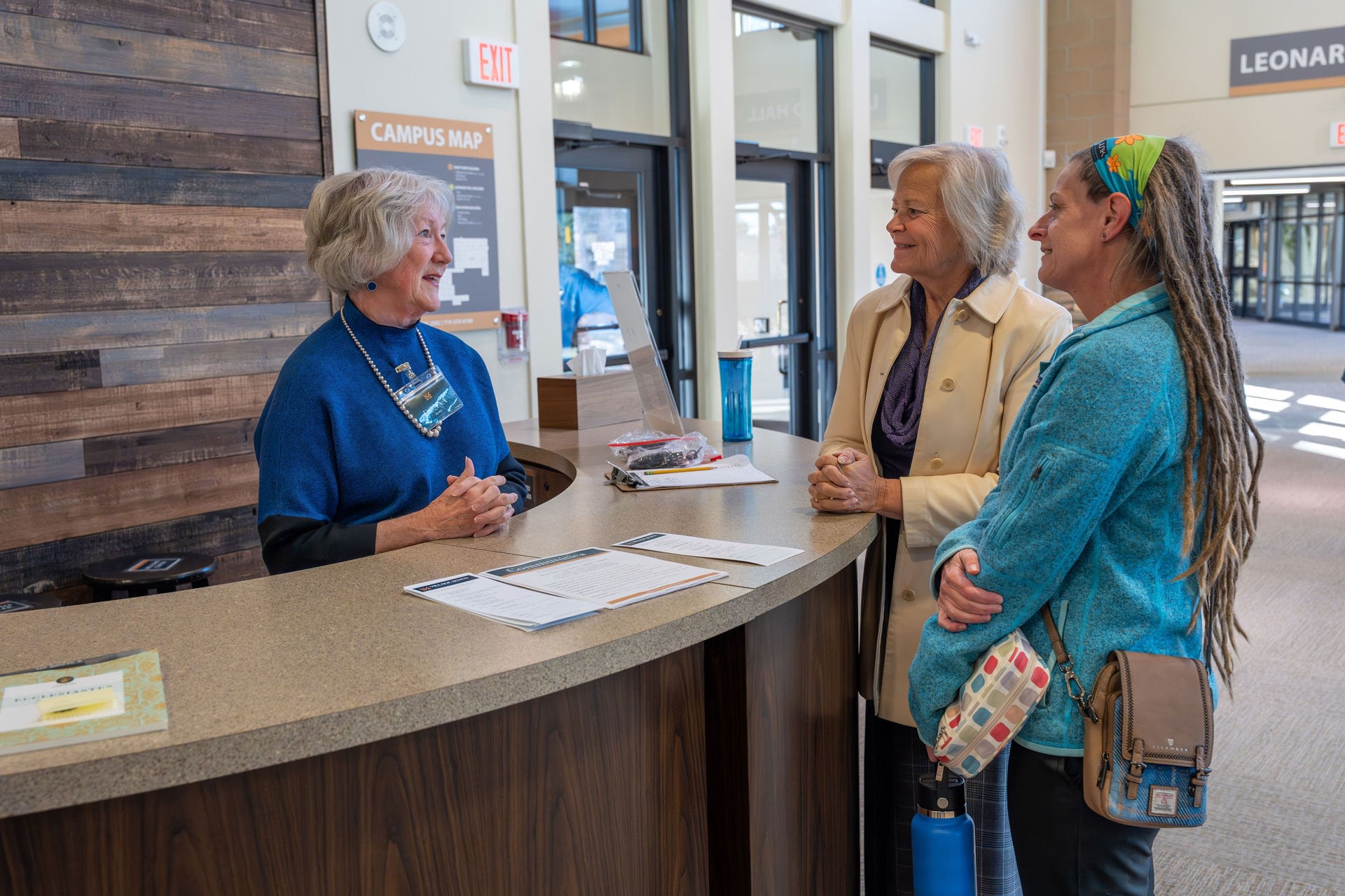 Women speaking at campus reception desk