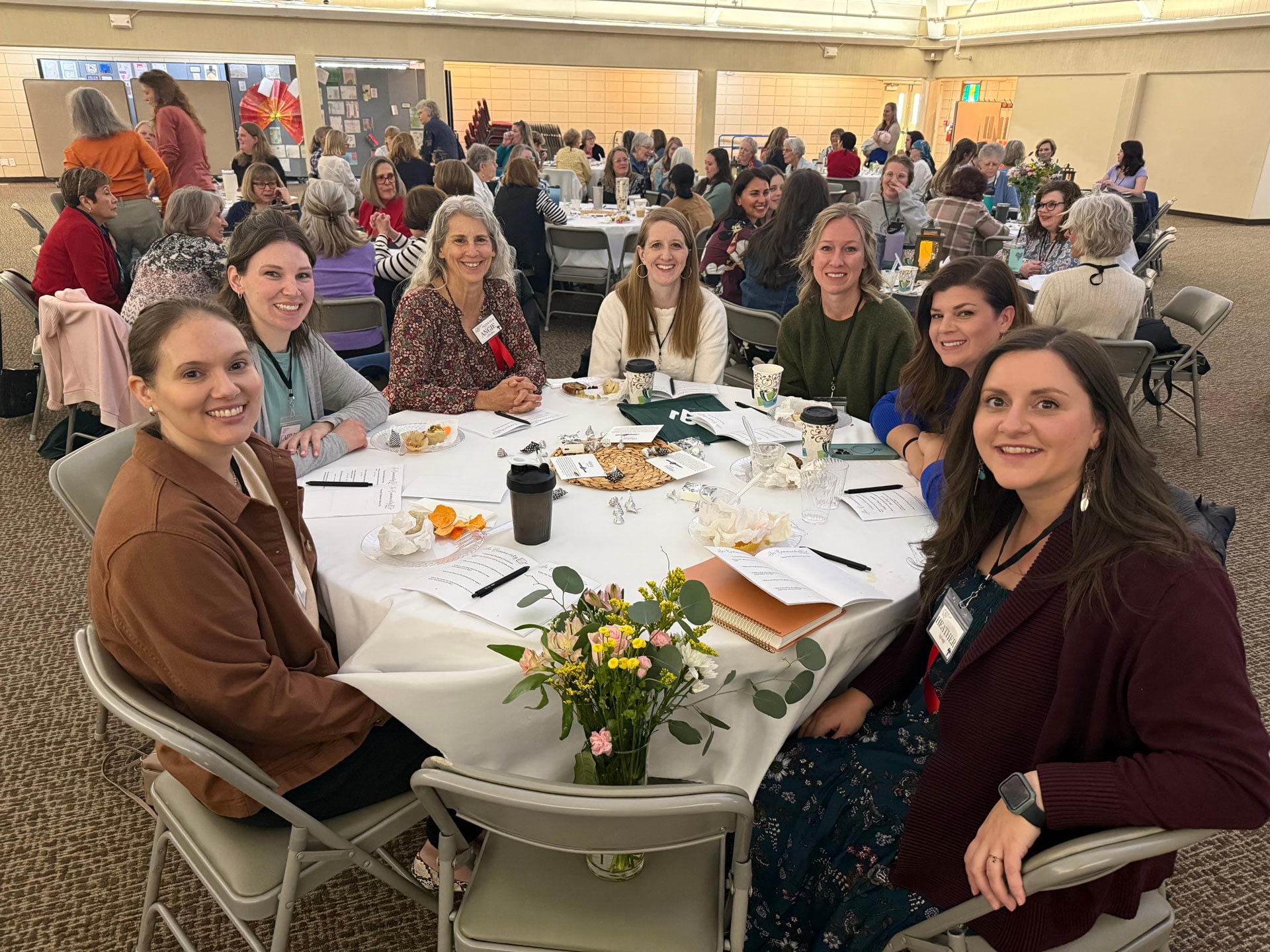 Women attending community luncheon seated at round tables