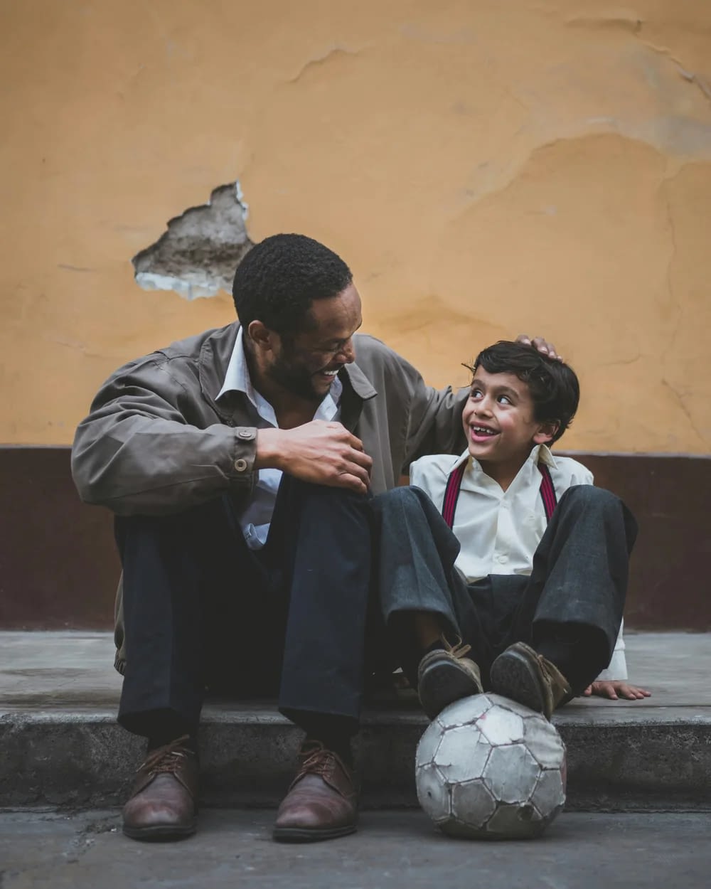 Father and son laughing with soccer ball