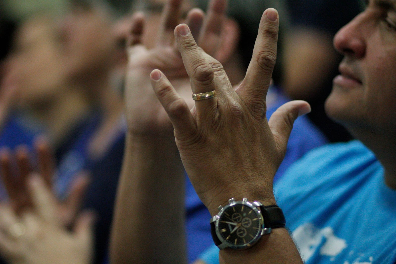 Person wearing black watch and gold ring.