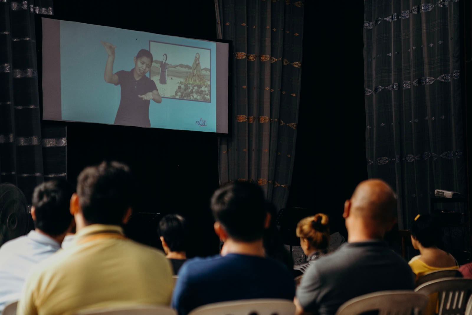 Audience watching a person sign language.