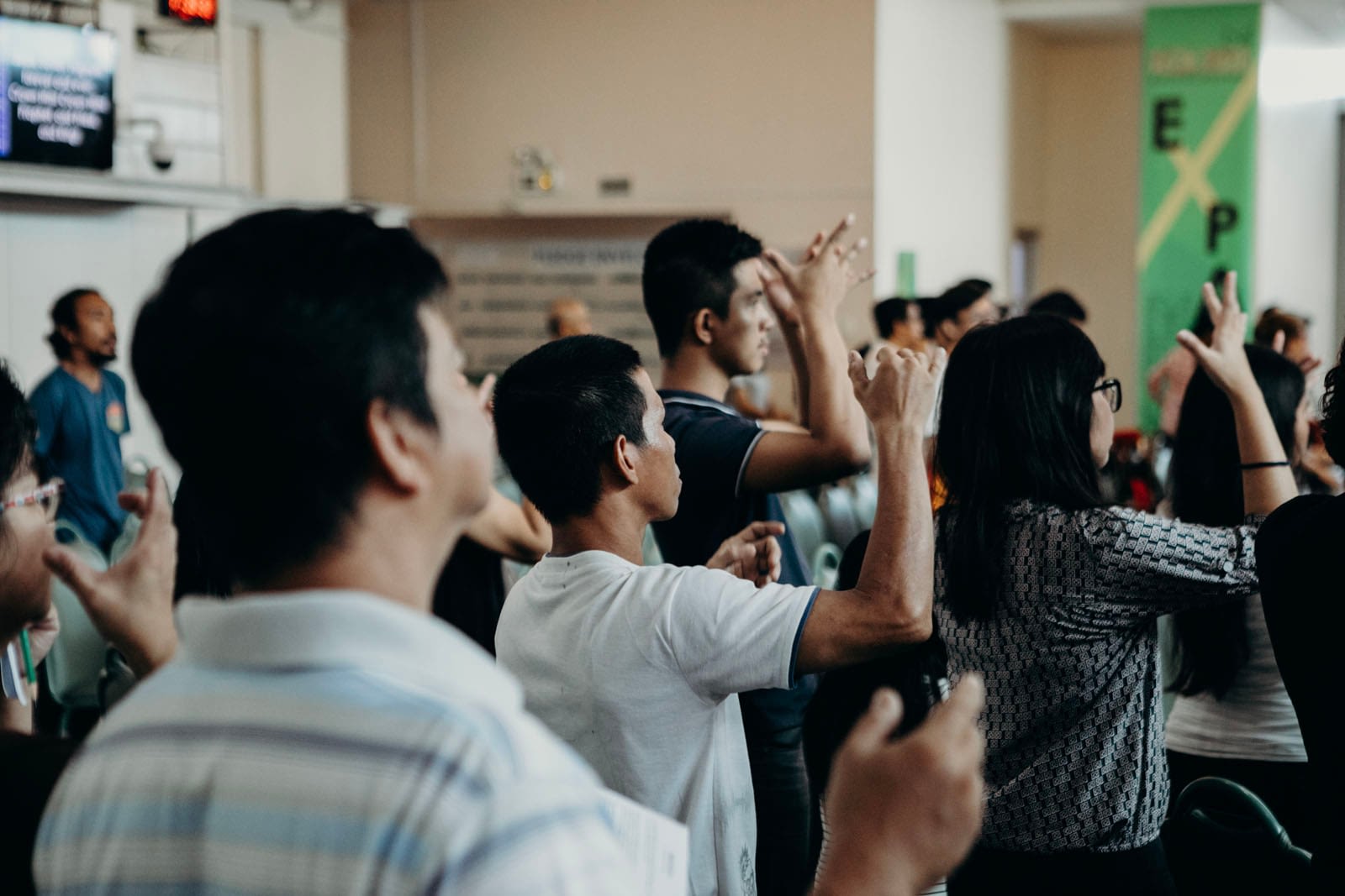 Group of people at event, hands raised.