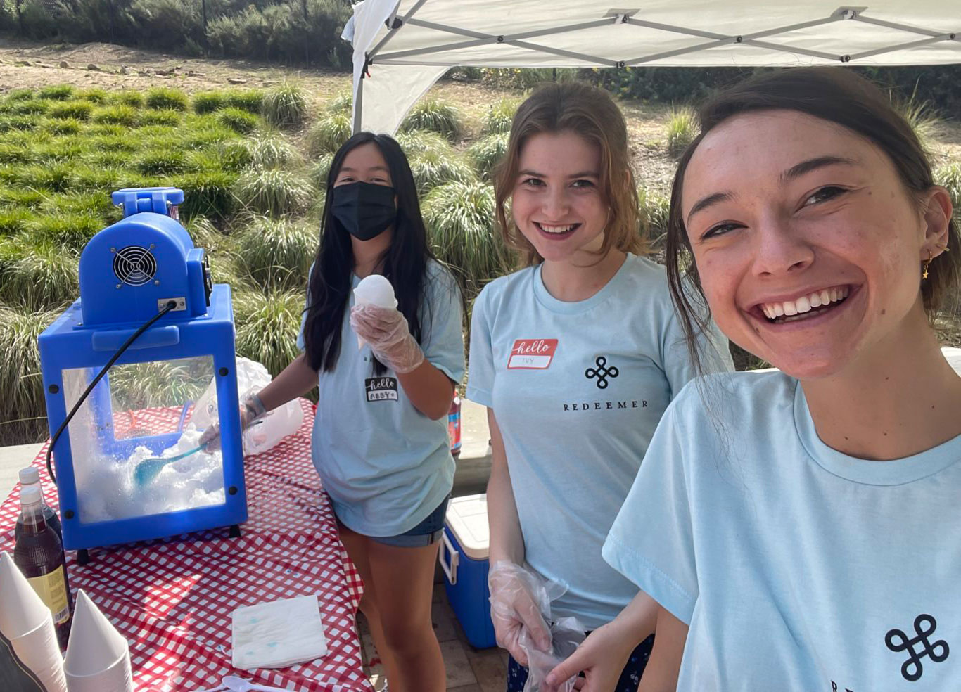 Smiling teens serving at a snow cone booth
