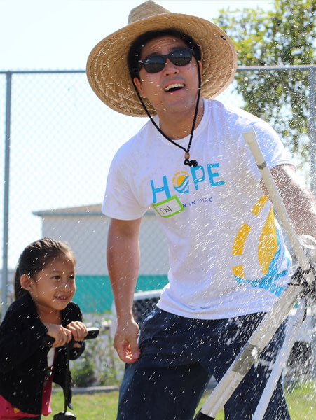 Chaperone and child playing with water at a fun community day