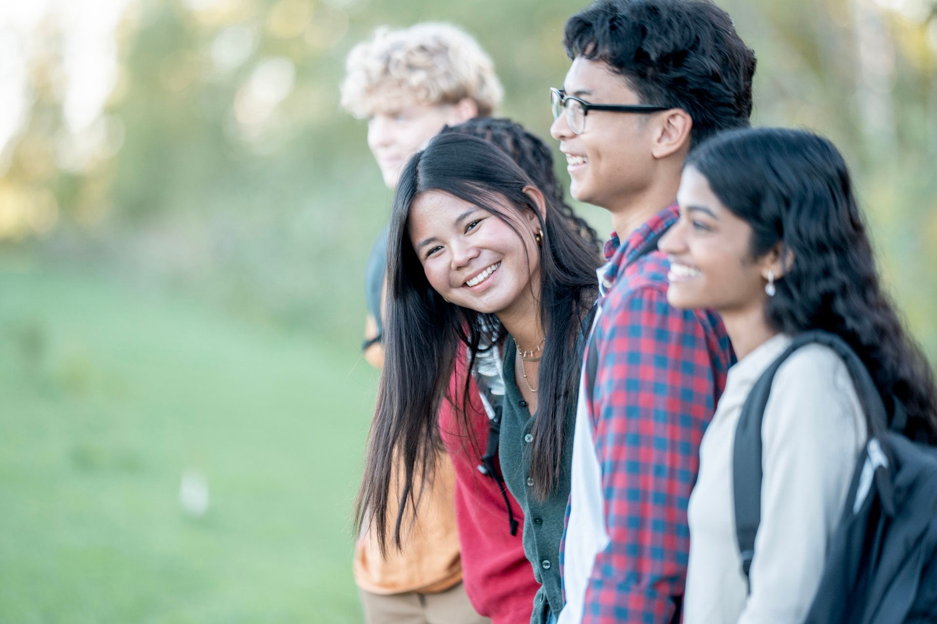 Smiling college students standing outdoors together