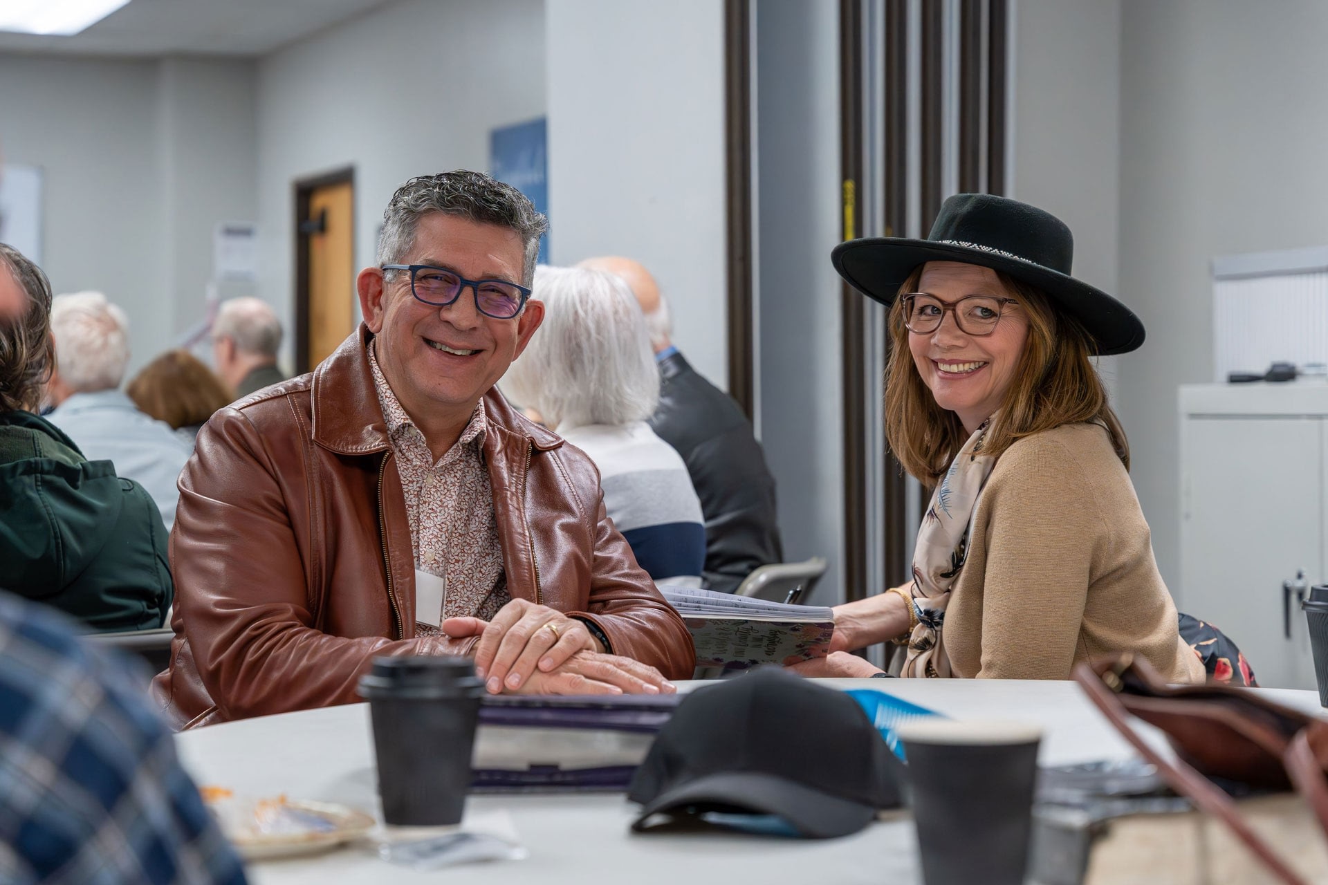 Smiling man and woman seated at meeting table