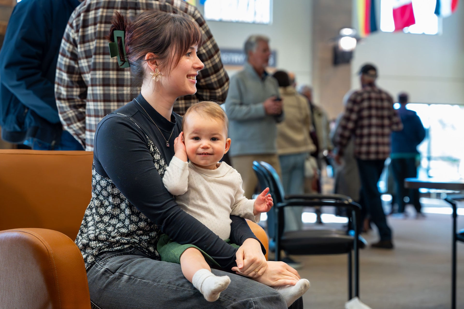 Mother holding baby in busy waiting area