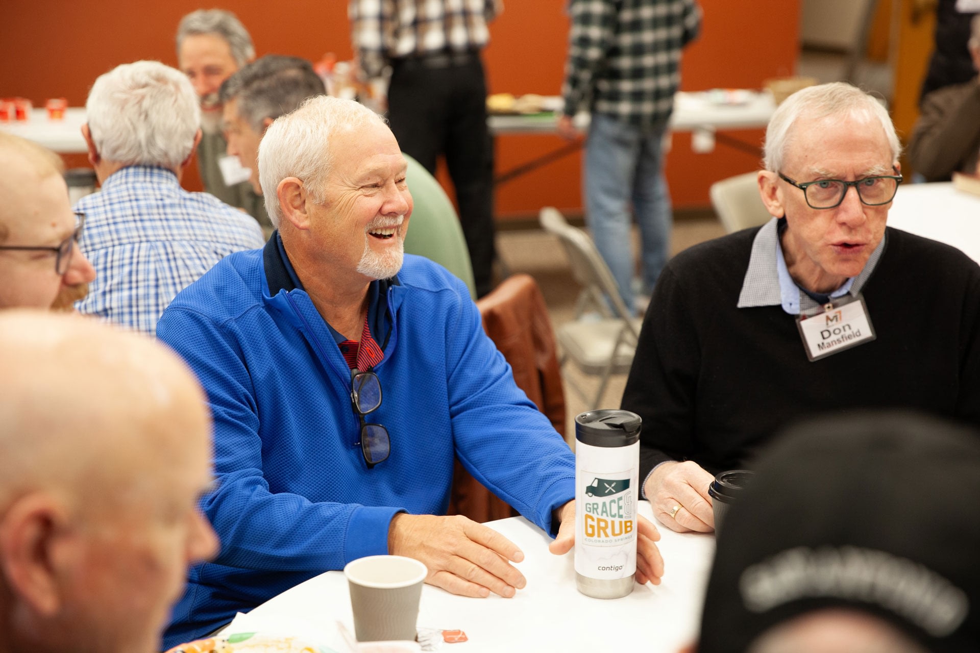 Senior men chatting at community gathering indoors