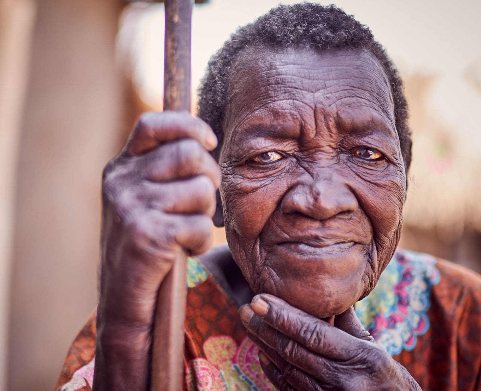 Widow holding a walking stick and resting hand on her chin