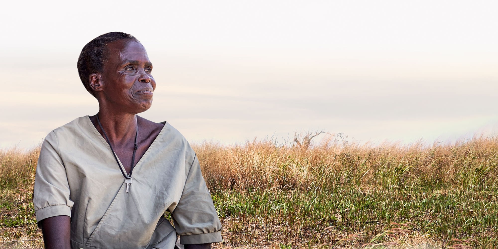 Dignified woman looking into the distance with a field behind her