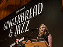 Woman speaks at Gingerbread and Jazz event podium