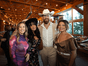 Four friends pose at a rustic Western-themed gathering