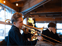Young musician playing trombone at a festive indoor venue
