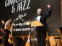 Tuxedoed speaker addresses audience at jazz charity event