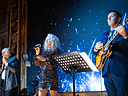 Singer and guitarists perform on a starry-lit stage