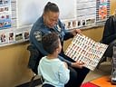 Police officer reads picture book to child in classroom