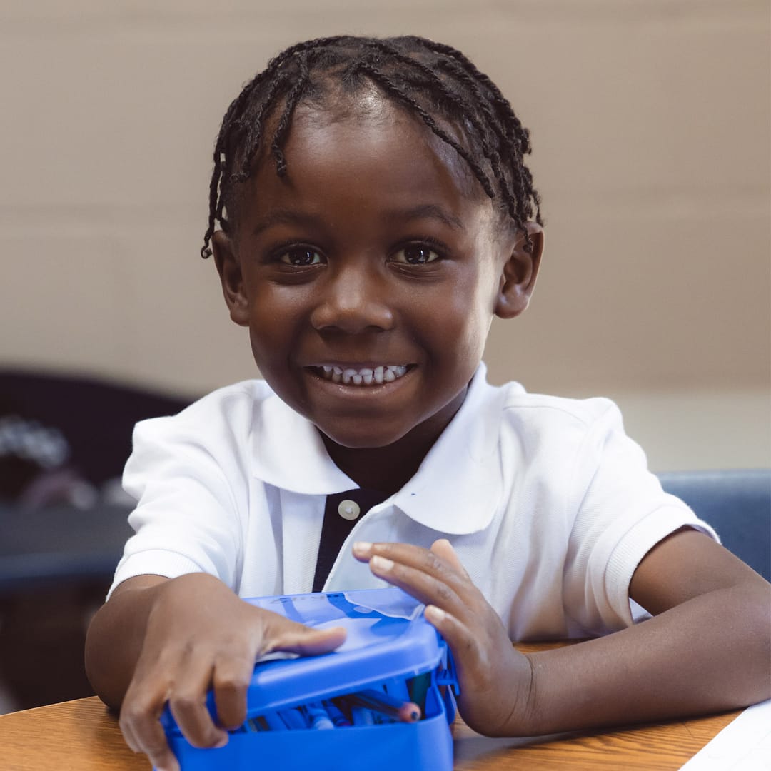 Student closes box of colored pencils.