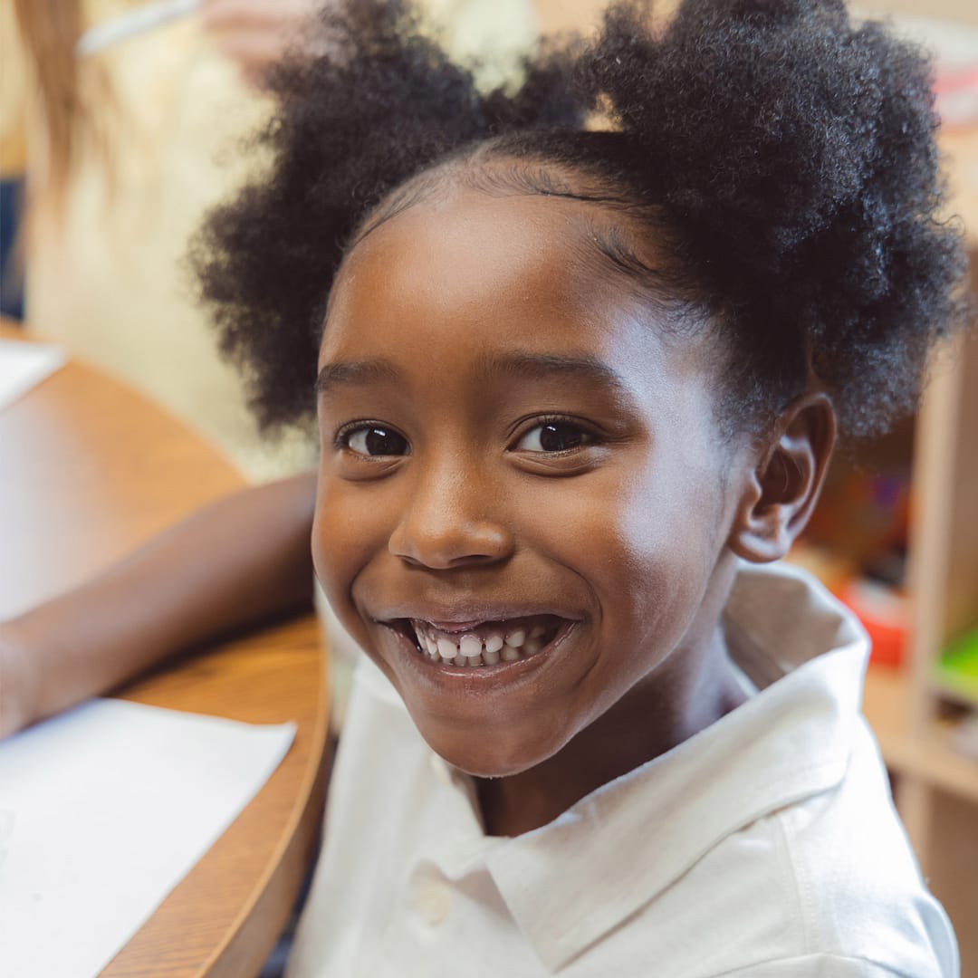 Girl works on paper in classroom.