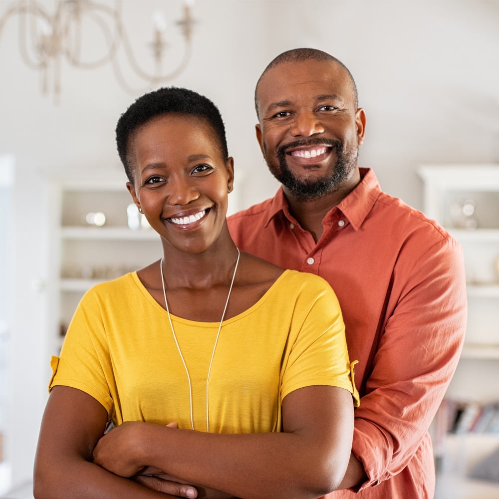 Smiling couple hugging at home