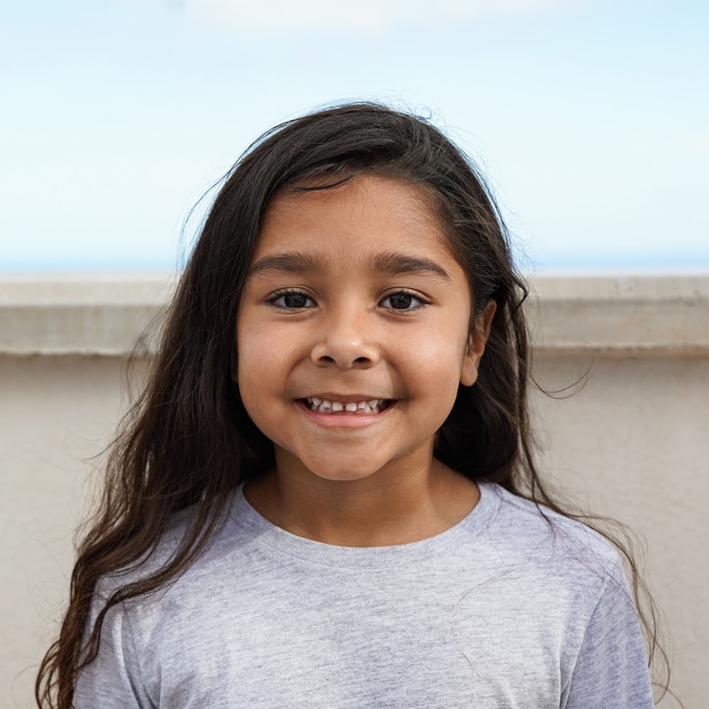 Smiling young girl with long hair outdoors