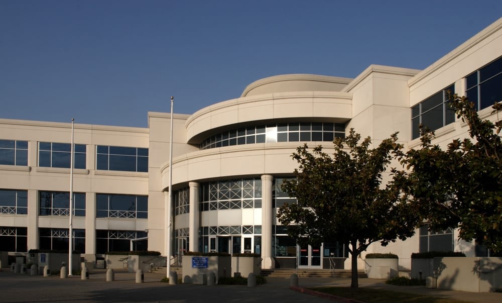 Modern office building with trees in front.