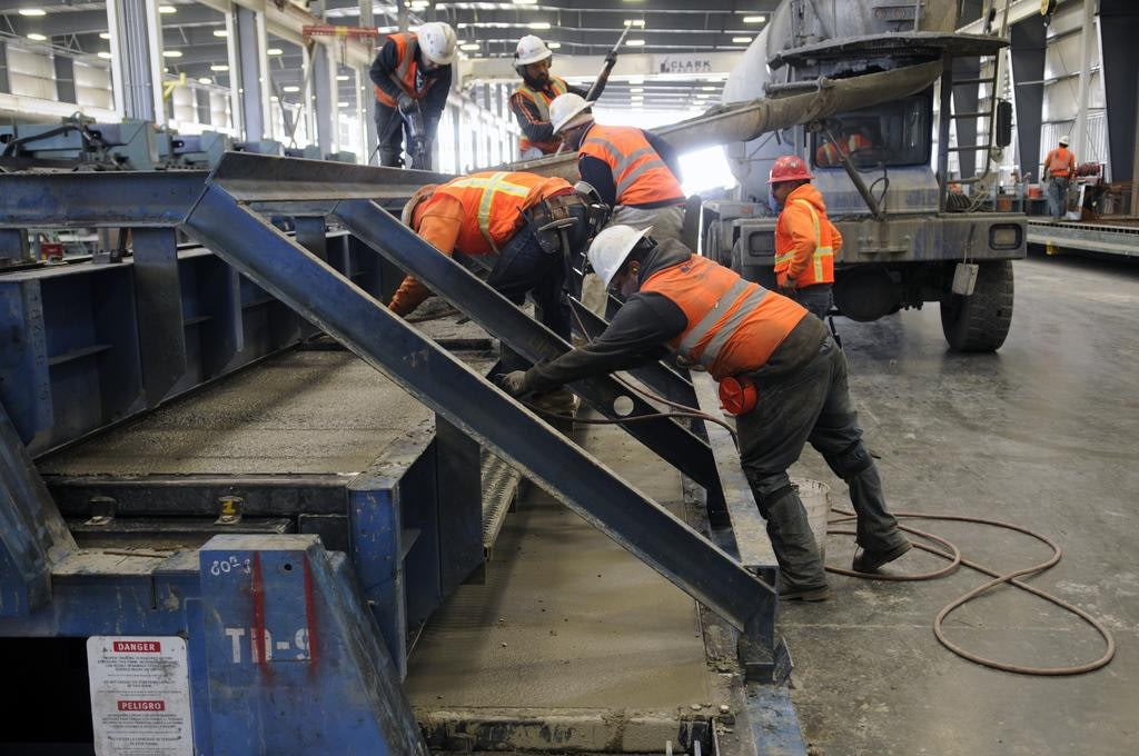 Construction workers pouring concrete indoors