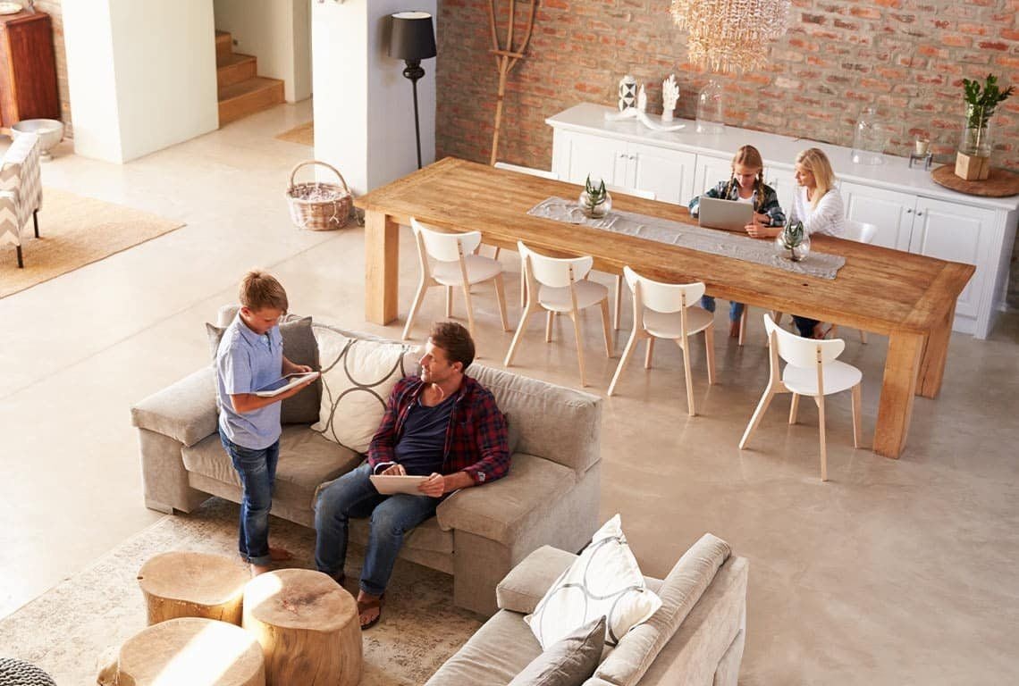 Family using devices in modern open-plan living room