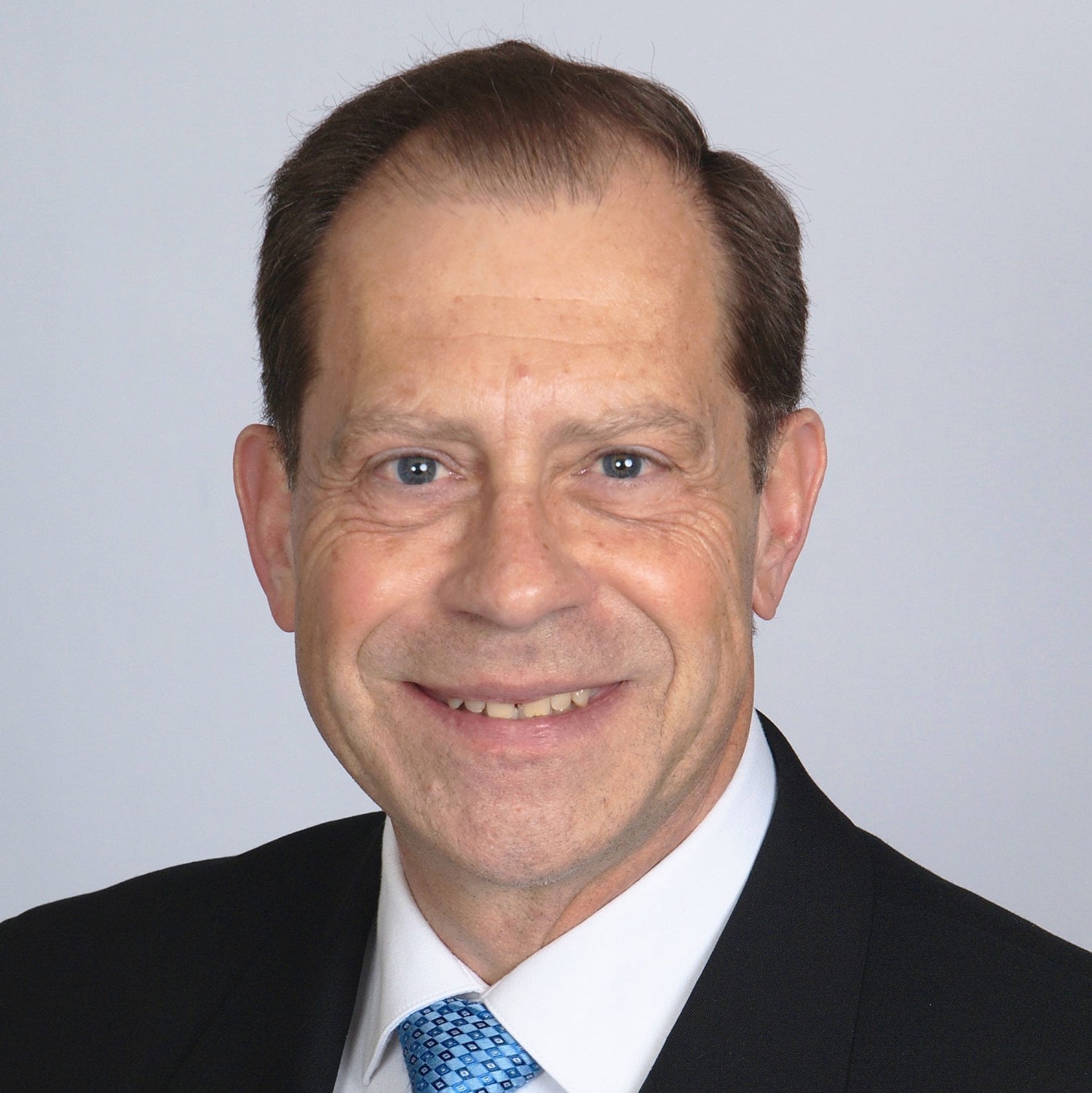 Smiling middle-aged man in suit and tie headshot