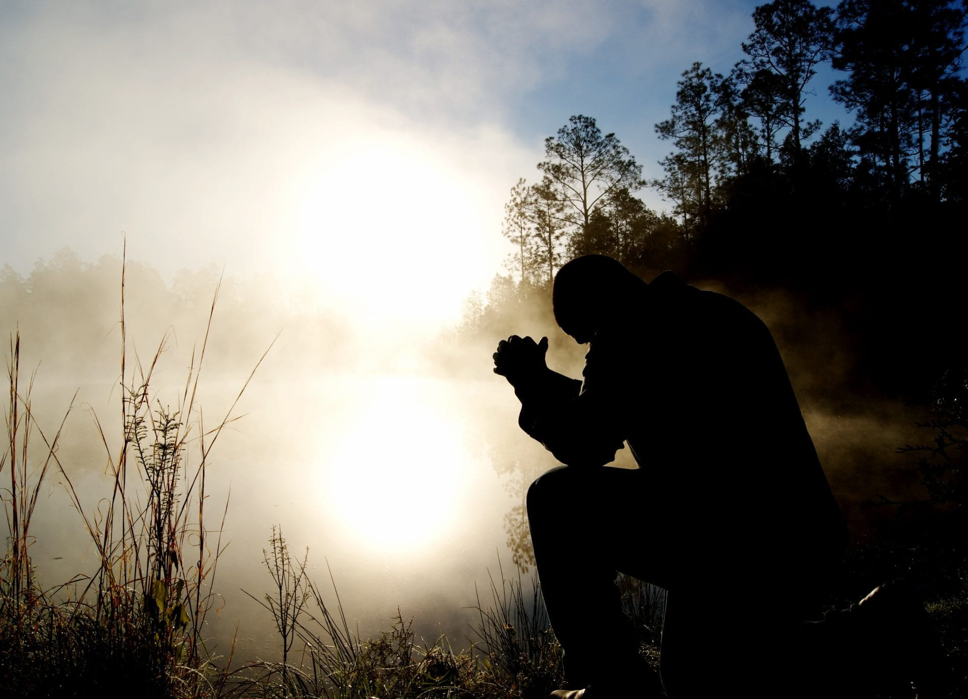 Man kneels in prayer.