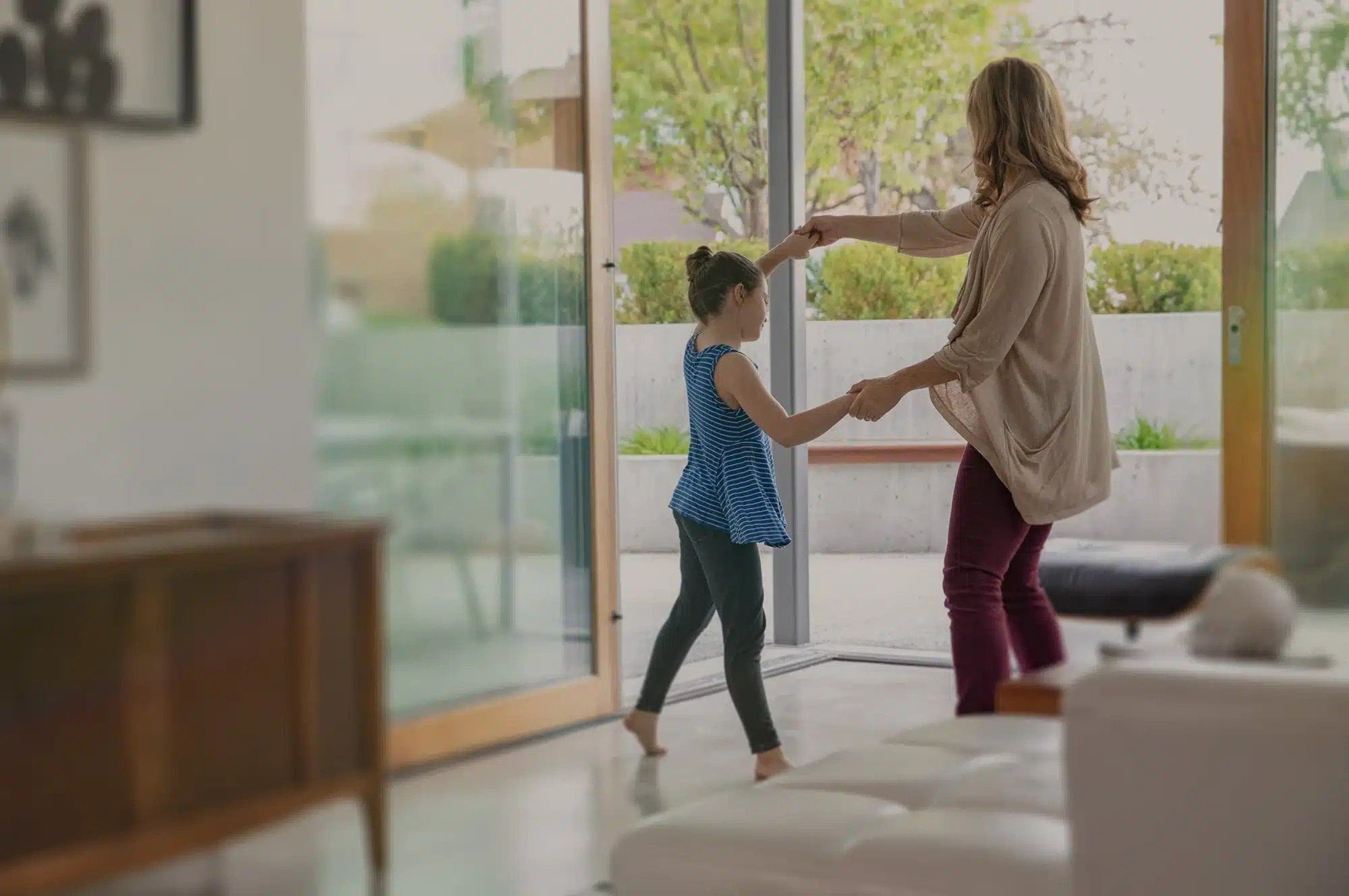 Mother and daughter dancing in living room