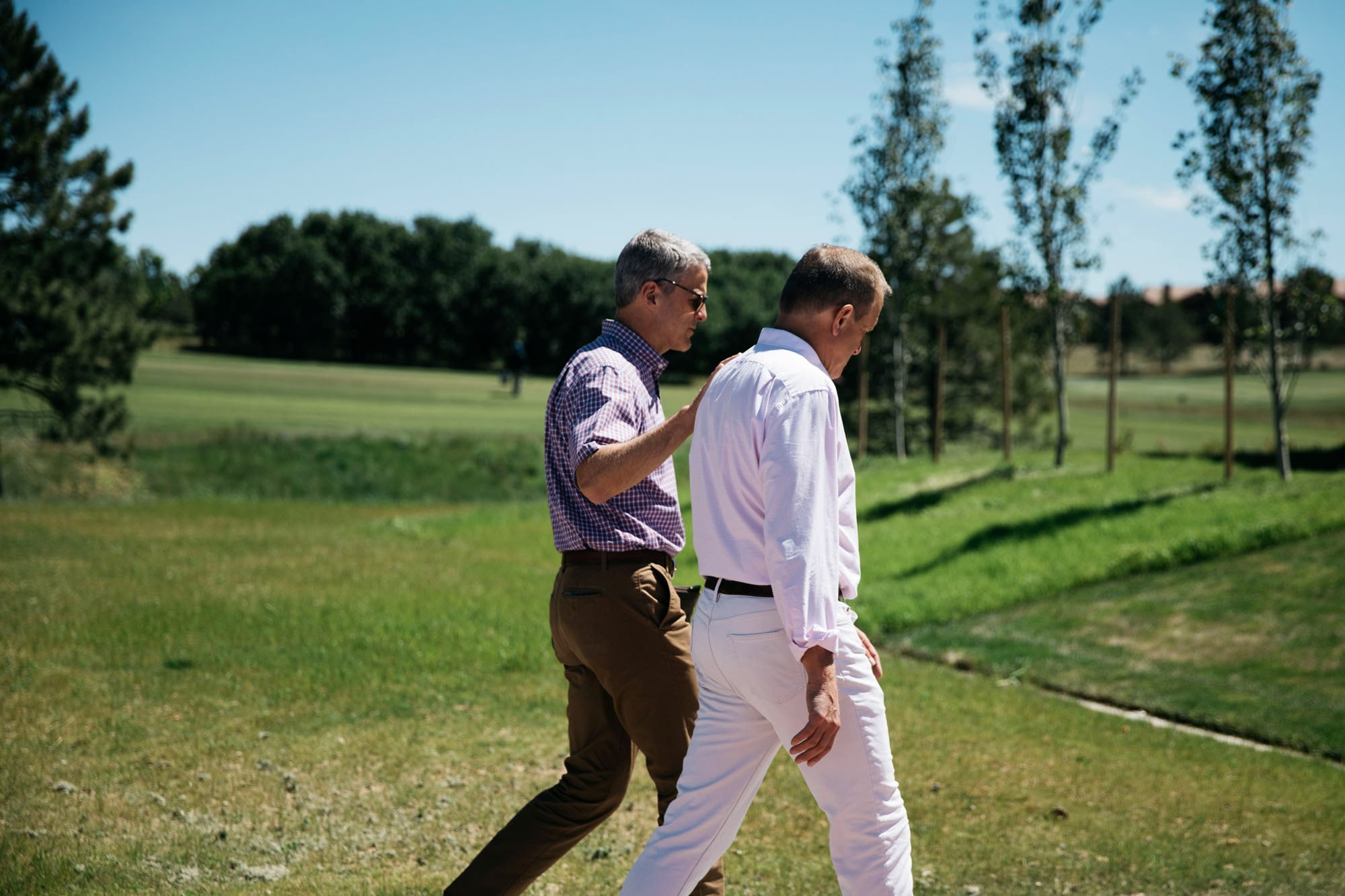 Two men walk and talk together.