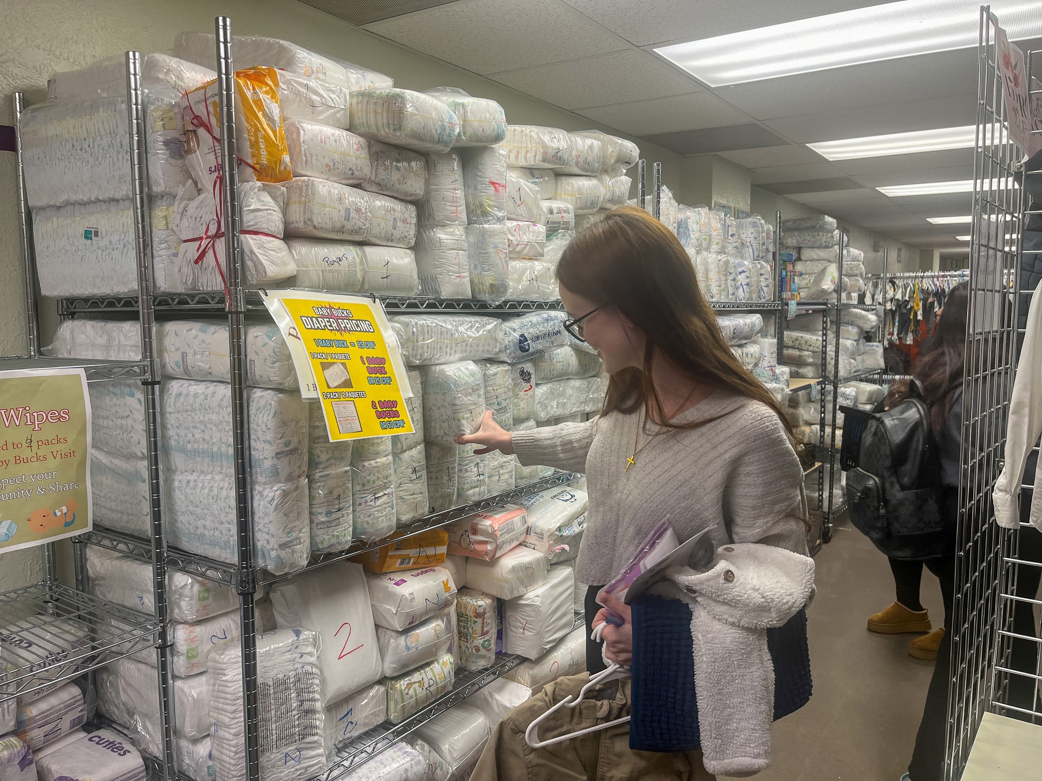 Woman shopping for diapers in a store.