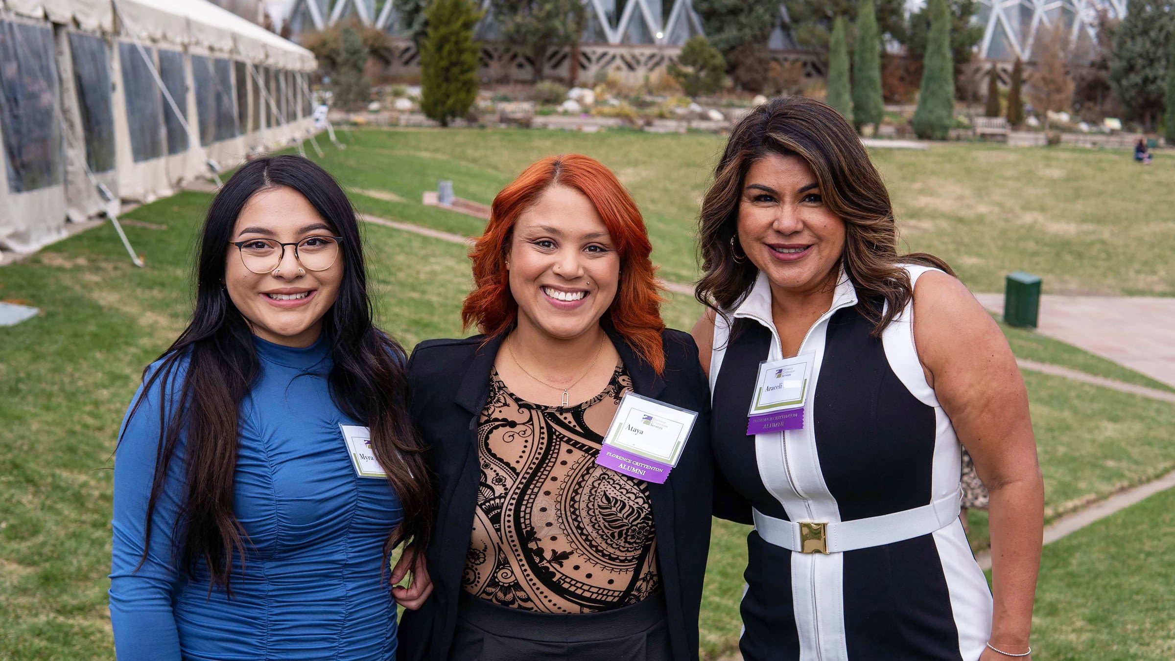 Three women smile for a group photo.