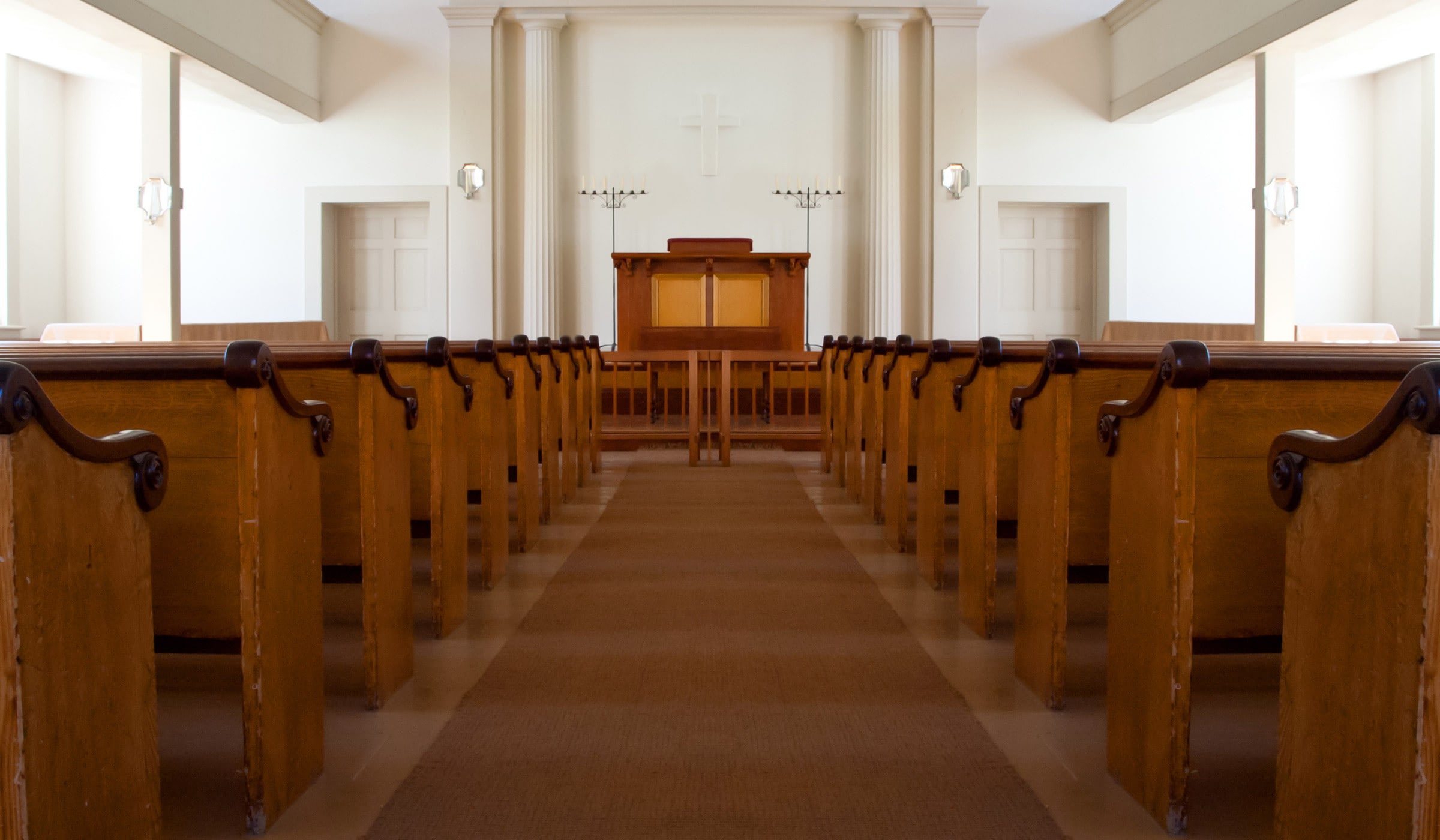 Empty church interior with wooden pews and altar.