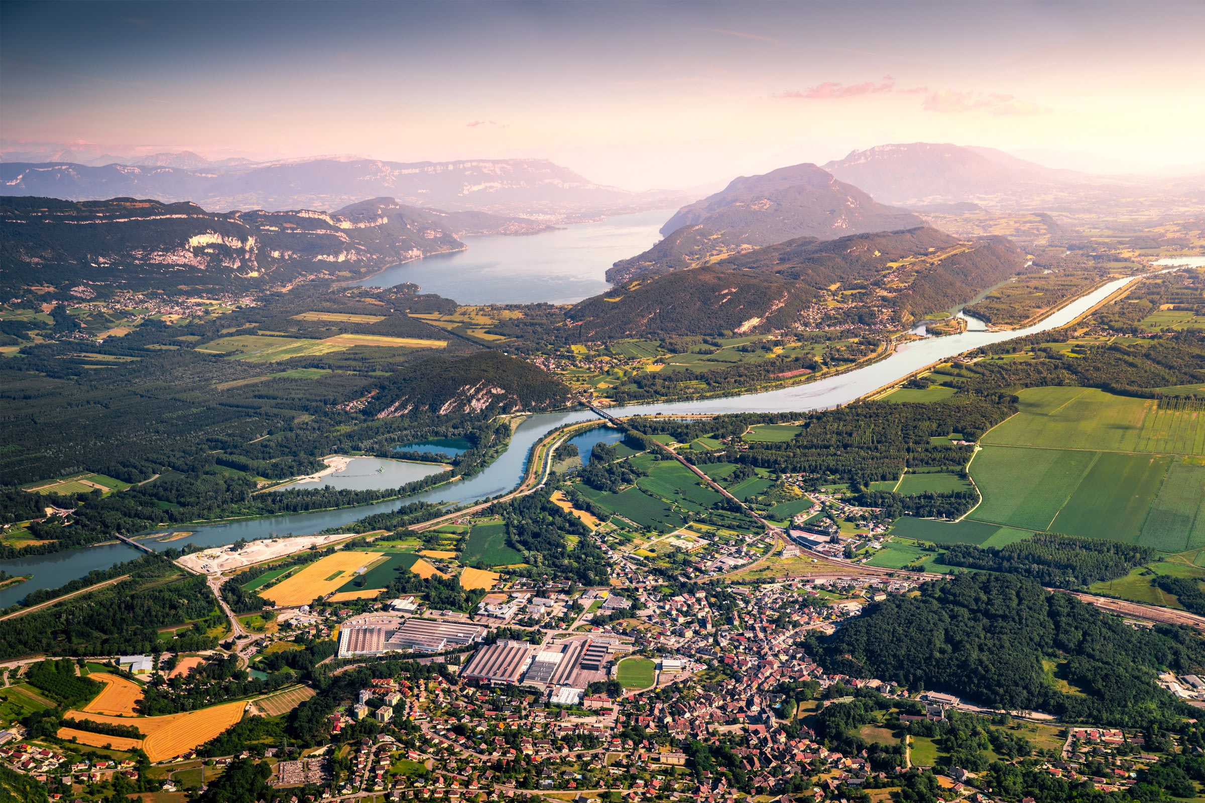 Aerial view of lush landscape with river and mountains.