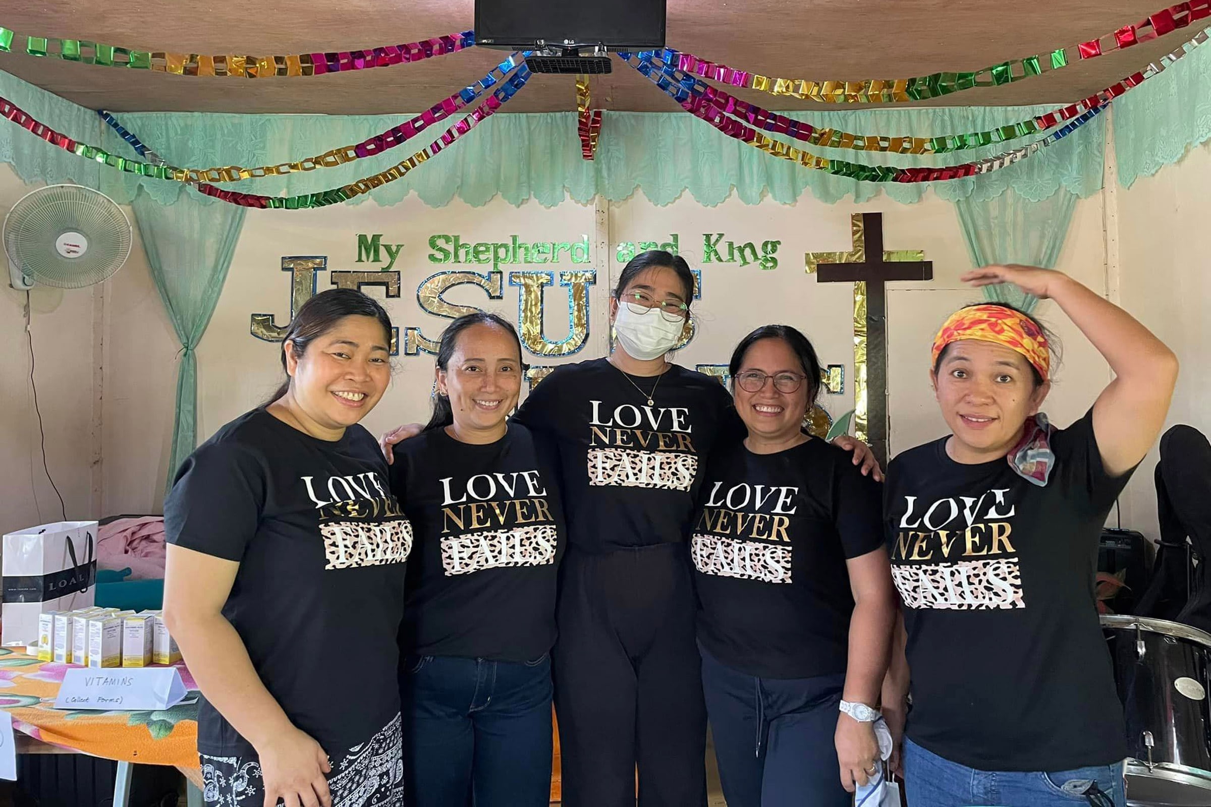 Group of women in matching shirts at church gathering.
