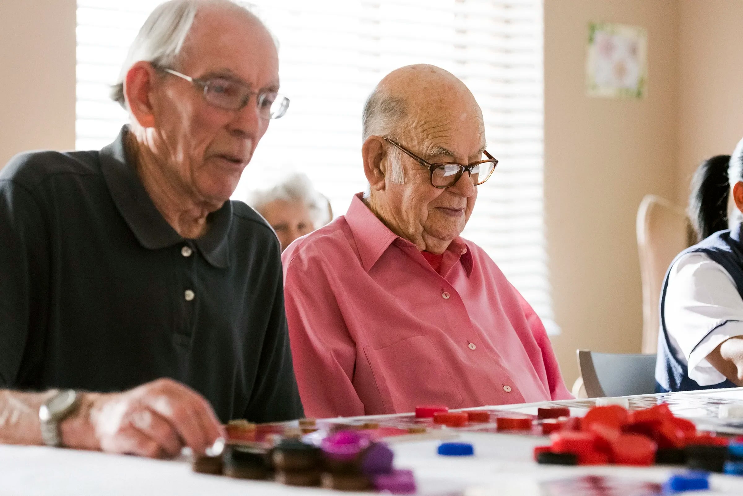 Elderly men playing board game at table