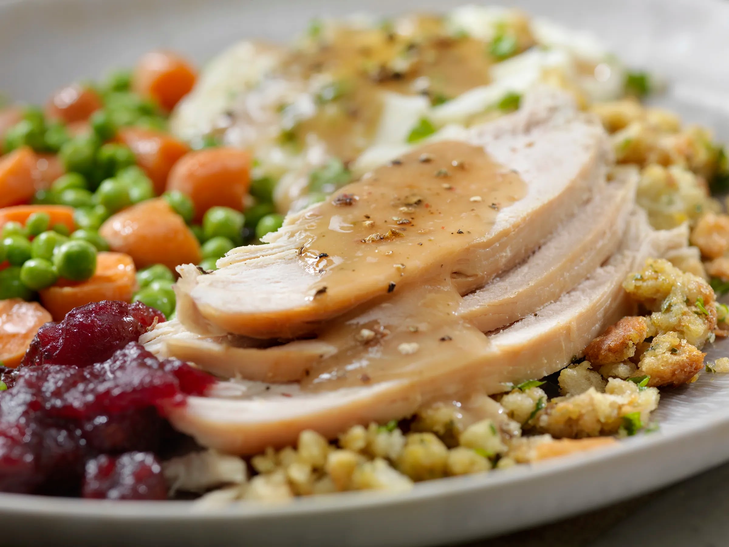 Sliced turkey with gravy and holiday sides