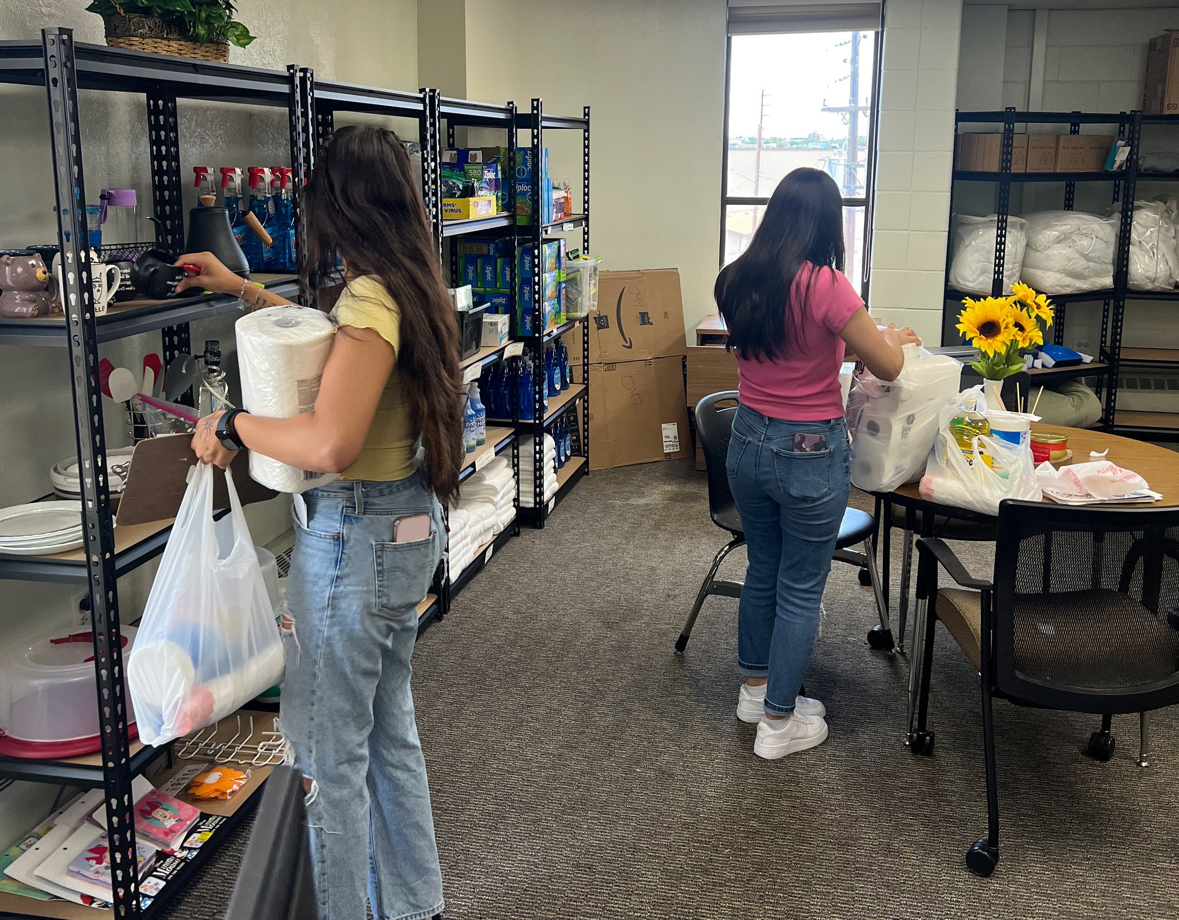 Two people organizing supplies in a storage room.