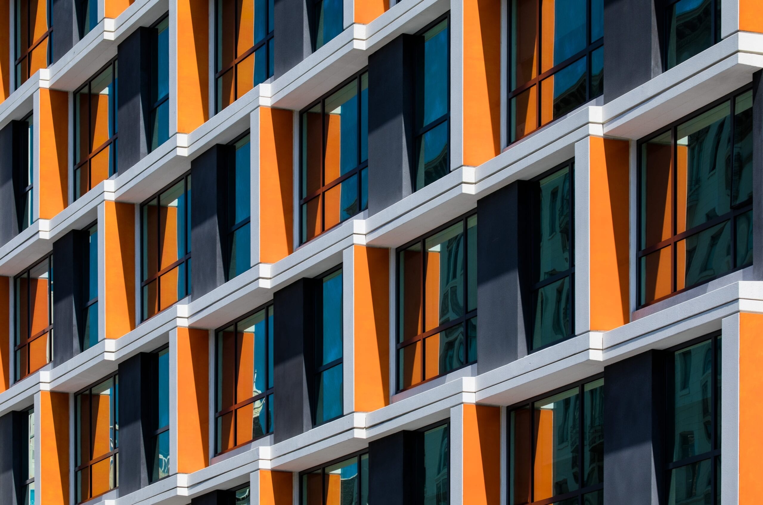 Modern building facade with orange and glass panels.