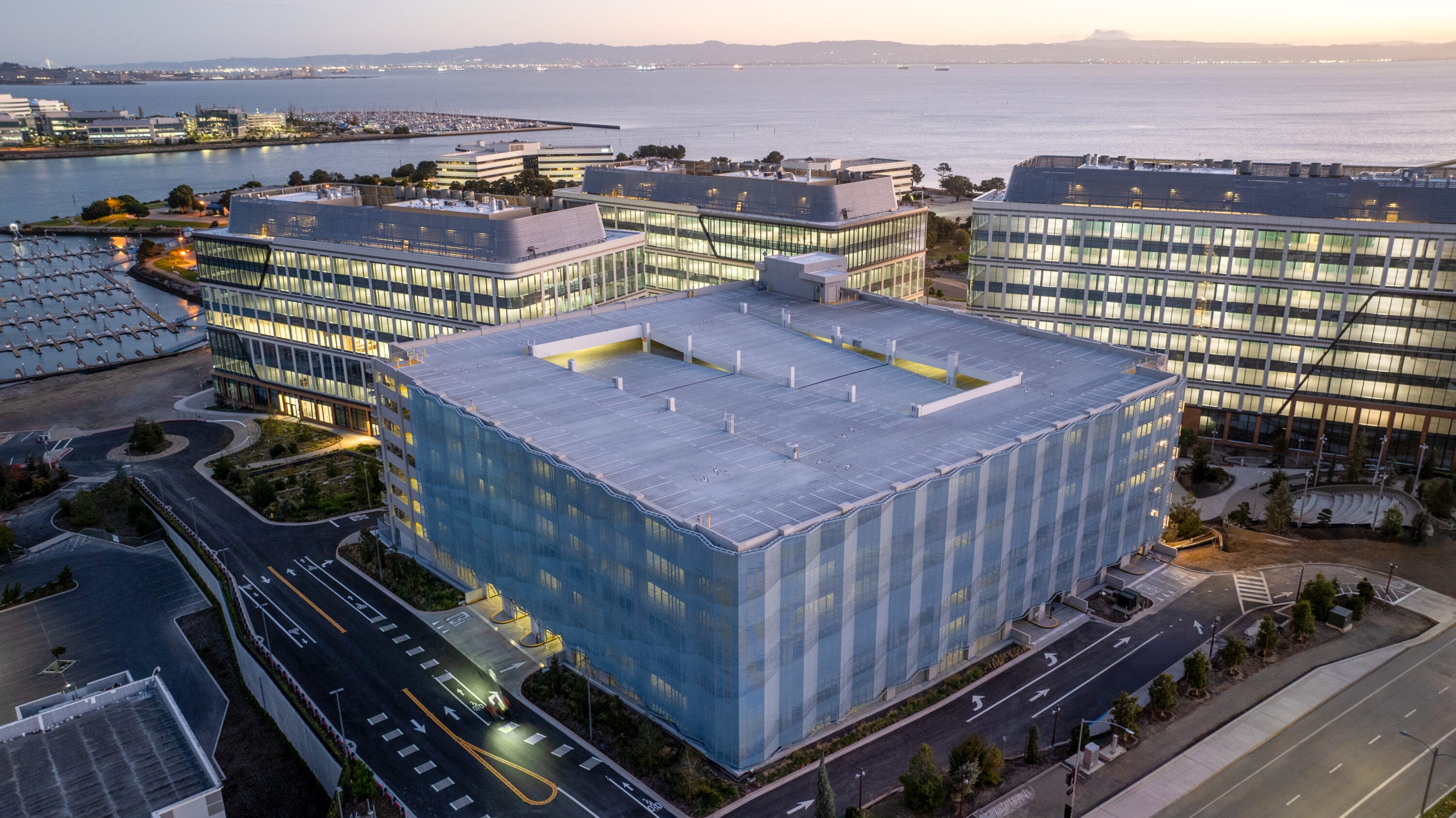 Aerial view of Kilroy Oyster Point Parking Structure by waterfront at sunrise.