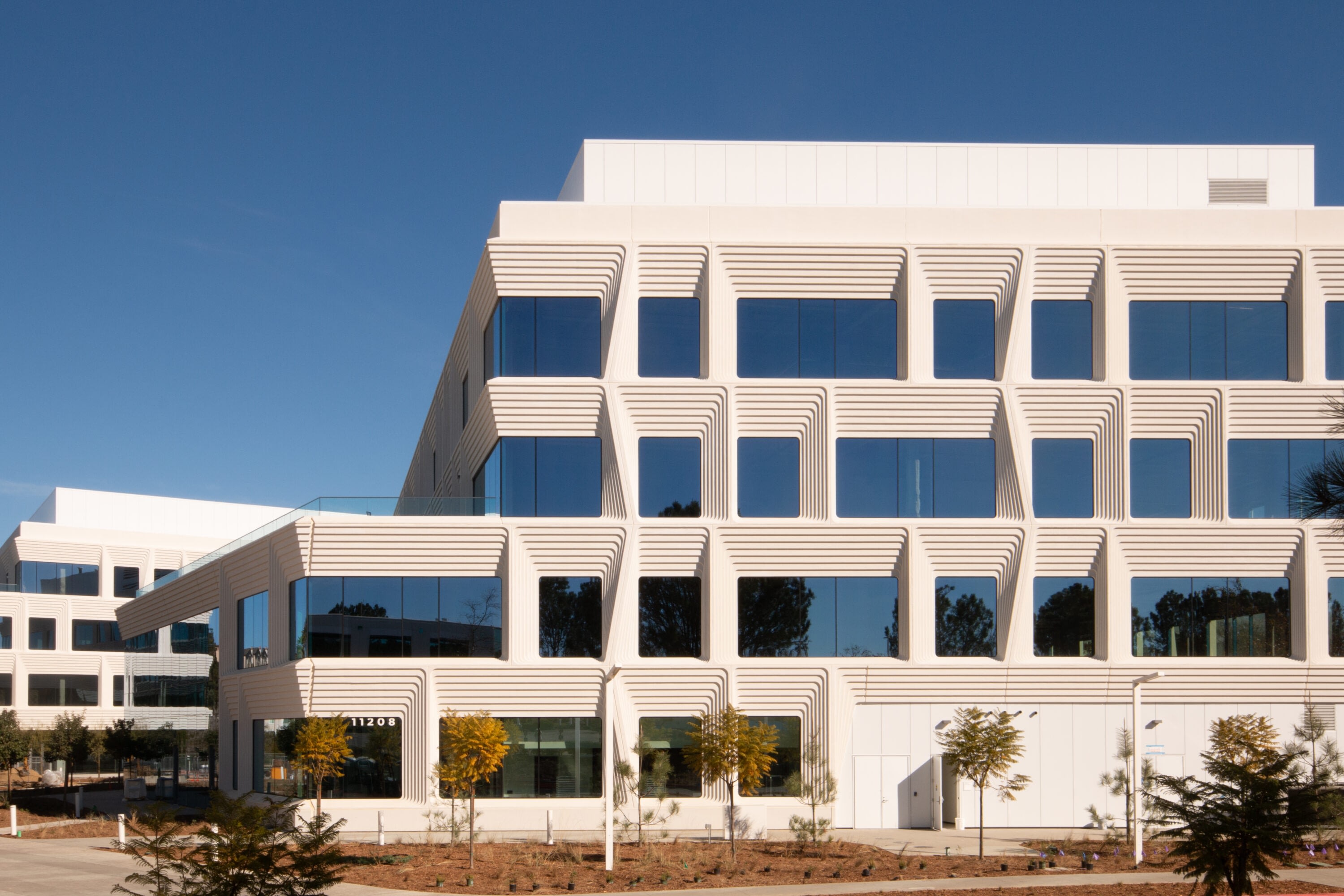 Modern white office building with geometric windows.