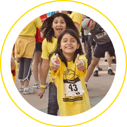Children running in a playful race, smiling.