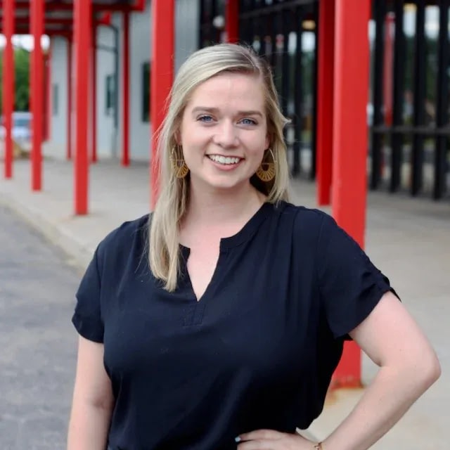Smiling woman standing beside red columns