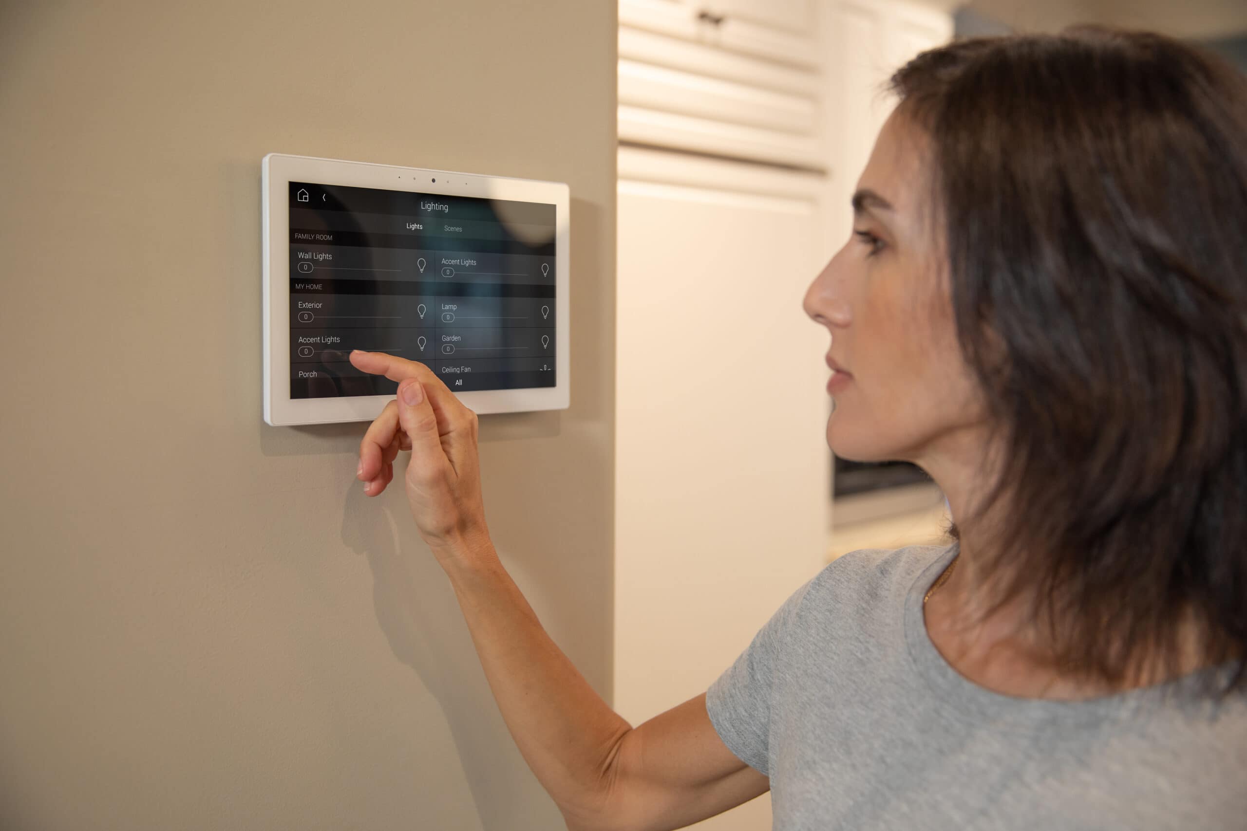 woman using control4 touchscreen on wall